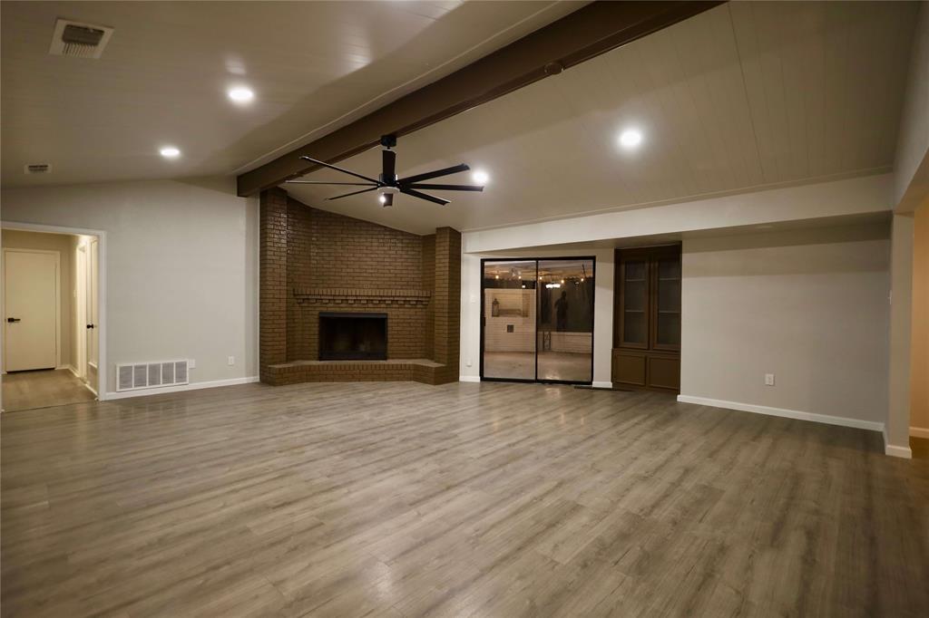 905 Pine Tree Lane DeSoto, TX 75115 - Photo 3 of 11 Unfurnished living room with a ceiling fan, light wood-type flooring, a brick fireplace, and recessed lighting