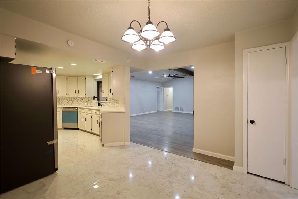 905 Pine Tree Lane DeSoto, TX 75115 - Photo 11 of 11 Kitchen featuring light marble finish flooring, stainless steel appliances, open floor plan, pendant lighting, and backsplash