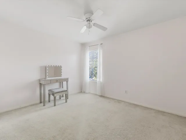 an empty room with a window and a ceiling fan