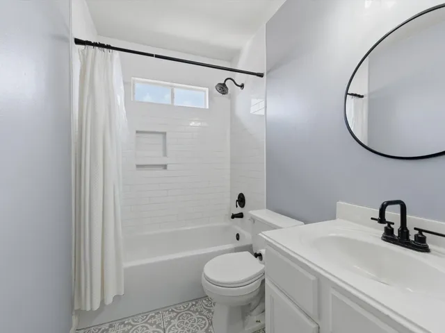 a bathroom with a sink a toilet and a mirror