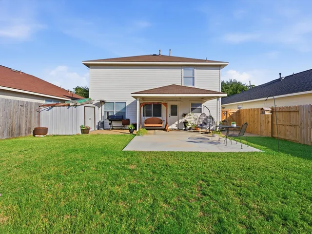 a view of a patio with table and chairs under an umbrella