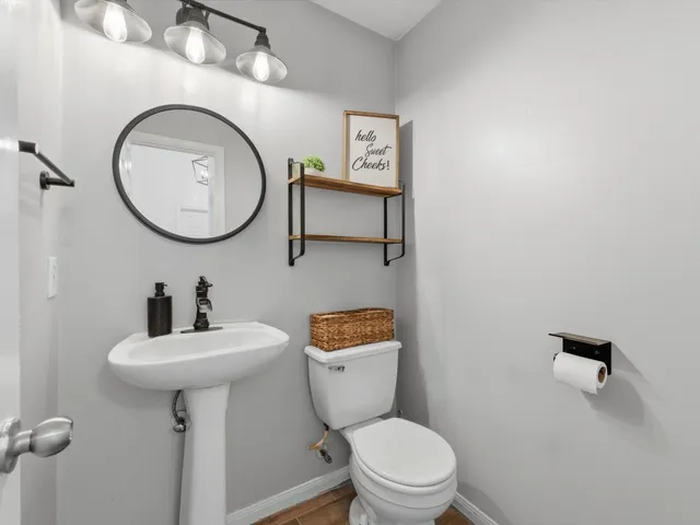 a bathroom with a toilet a sink and mirror