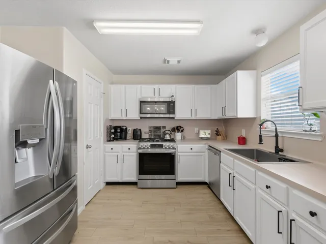 a kitchen with stainless steel appliances granite countertop a refrigerator sink and stove