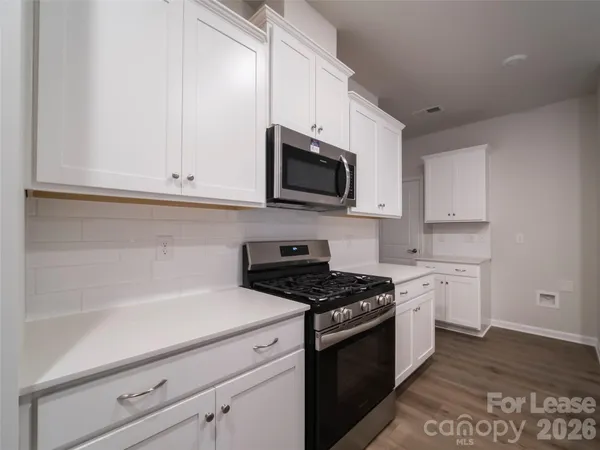 a kitchen with stove cabinets and wooden floor
