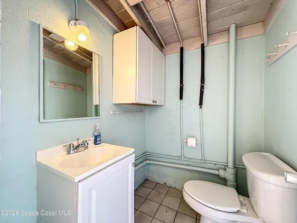 a bathroom with a sink a toilet a mirror and shower