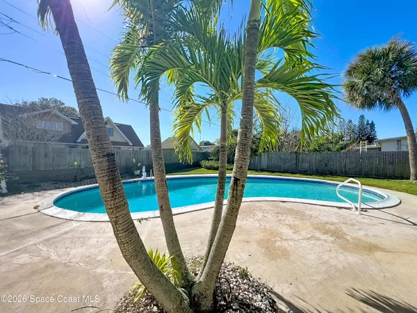 a view of a backyard with swimming pool