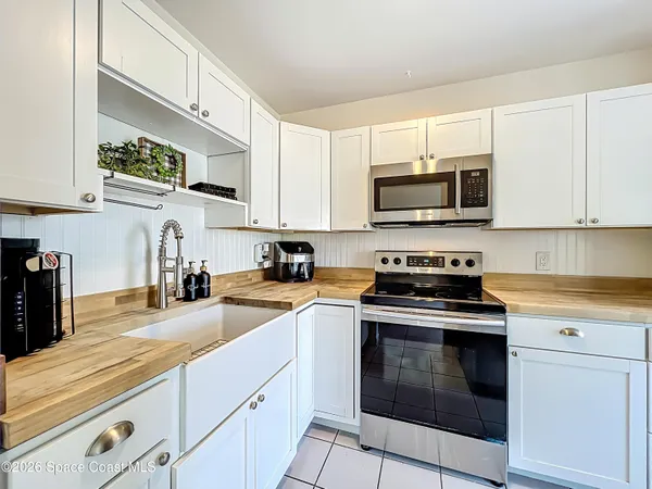 a kitchen with granite countertop a stove top oven microwave and cabinets