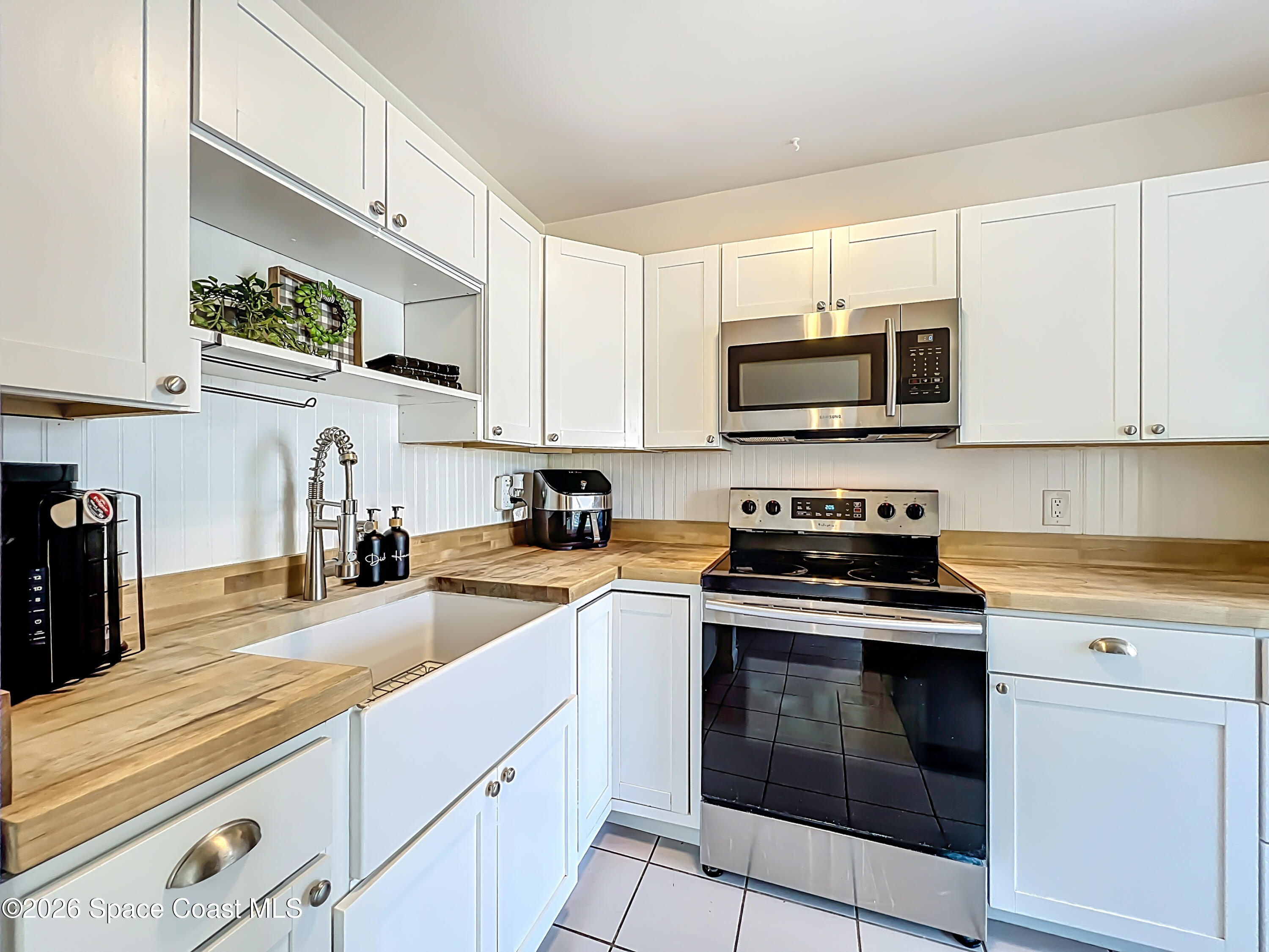 1090 Bianca Drive Northeast Palm Bay, FL 32905 - Photo 6 of 30 a kitchen with granite countertop a stove top oven microwave and cabinets