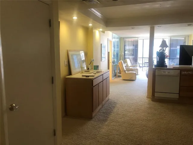 a view of a room with kitchen island stainless steel appliances wooden floor and living room view