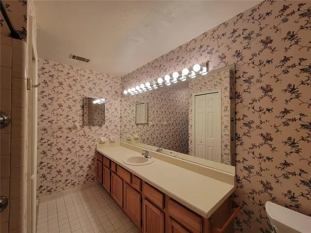 a bathroom with a sink a toilet and a mirror