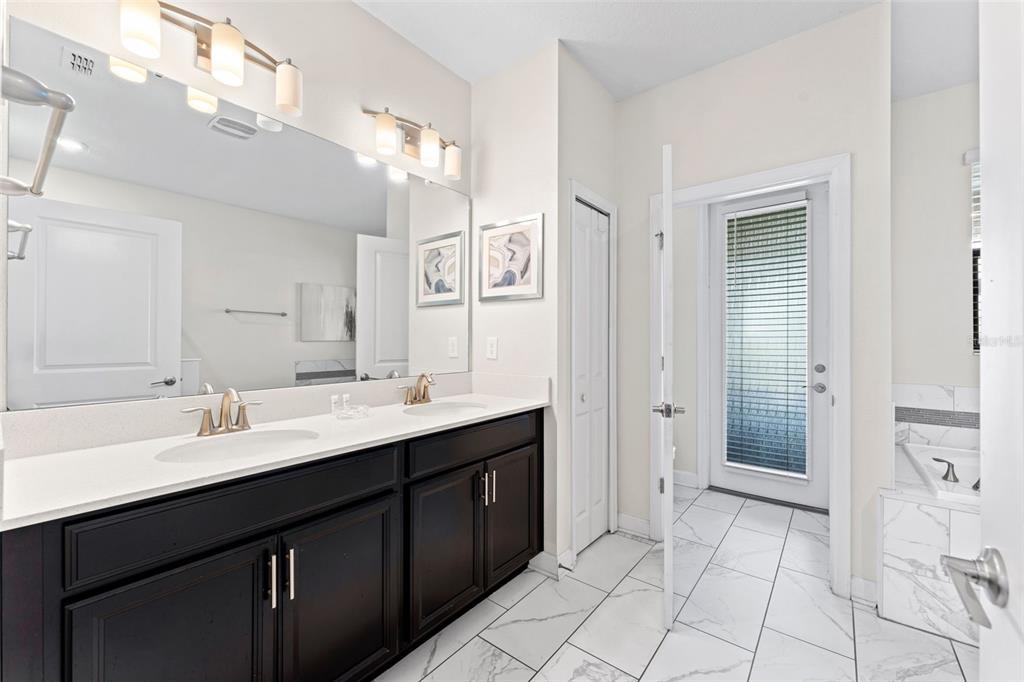 2933 Fable Street Kissimmee, FL 34746 - Photo 17 of 53 a spacious bathroom with a double vanity sink a mirror and a
