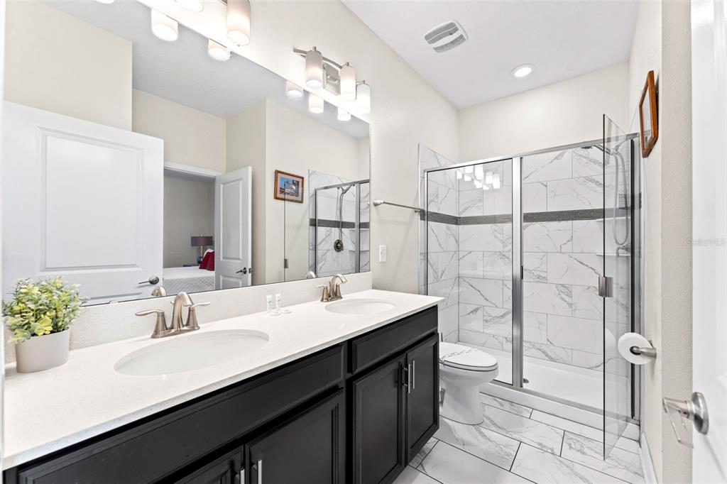 2933 Fable Street Kissimmee, FL 34746 - Photo 22 of 53 a bathroom with a double vanity sink mirror and shower