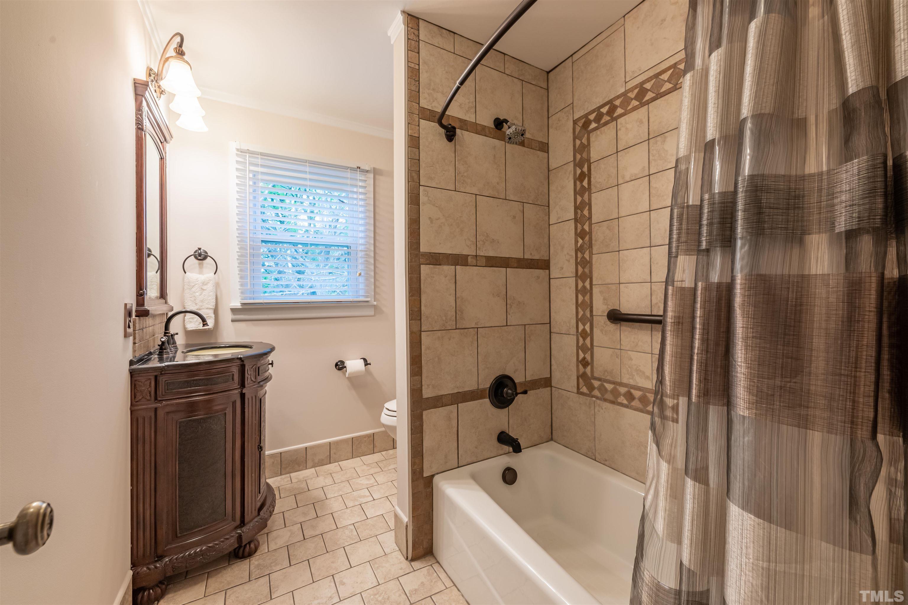 3101 Sherry Drive Raleigh, NC 27604 - Photo 17 of 28 a bathroom with a granite countertop sink a toilet and shower