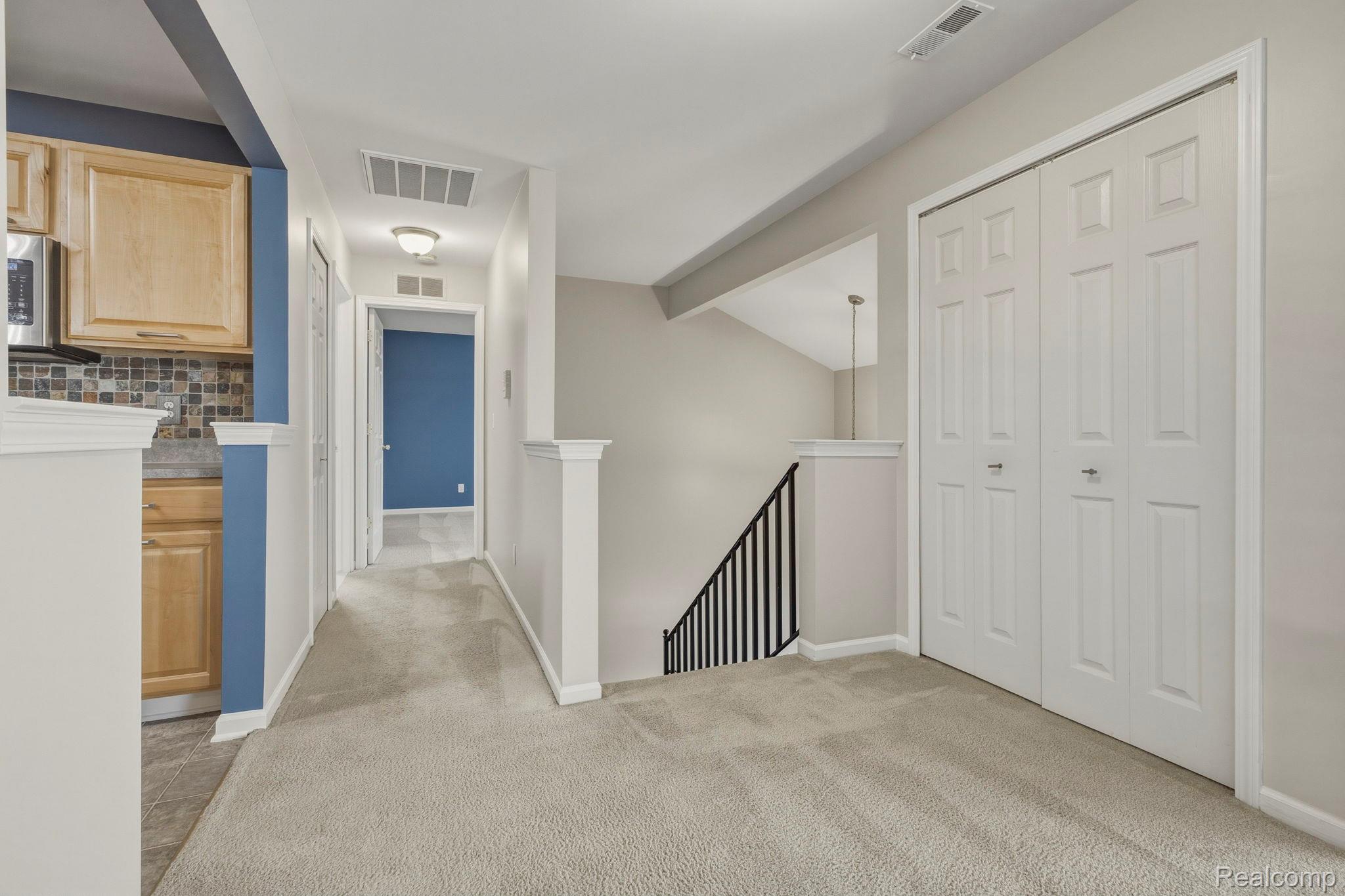 1905 Flagstone Circle Rochester, MI 48307 - Photo 15 of 33 Light-colored carpeting, white paneled bifold doors, and a staircase with black metal balusters