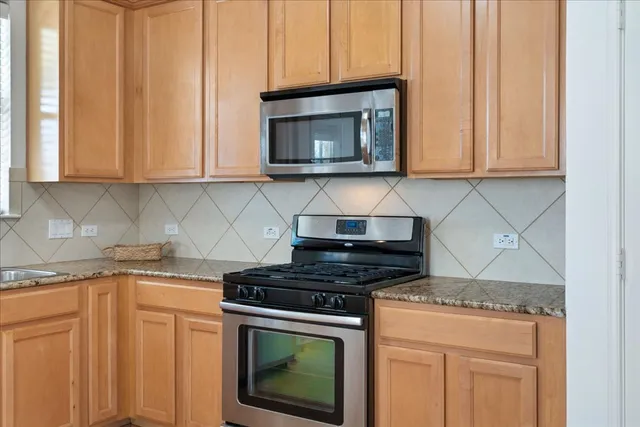 a kitchen with granite countertop cabinets stainless steel appliances and a sink