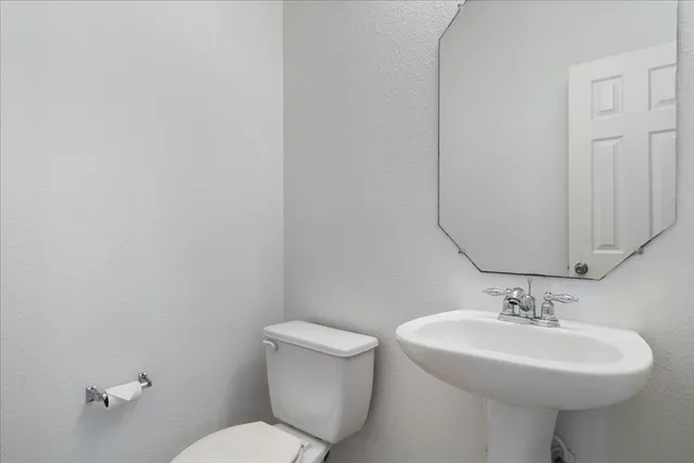 a bathroom with a sink a toilet and mirror