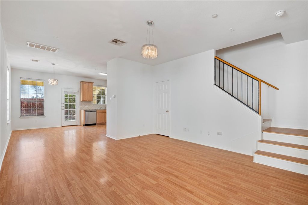 14815 Avery Ranch Boulevard, Unit 302 Austin, TX 78717 - Photo 2 of 28 a view of an empty room with wooden floor and a kitchen