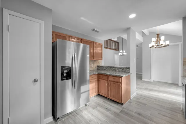 a kitchen with stainless steel appliances granite countertop a refrigerator and a stove