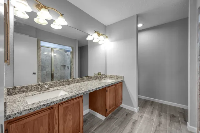 a bathroom with a granite countertop sink a light fixture and a mirror