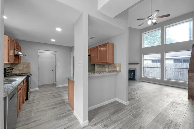 a kitchen with granite countertop a stove top oven a sink and a refrigerator
