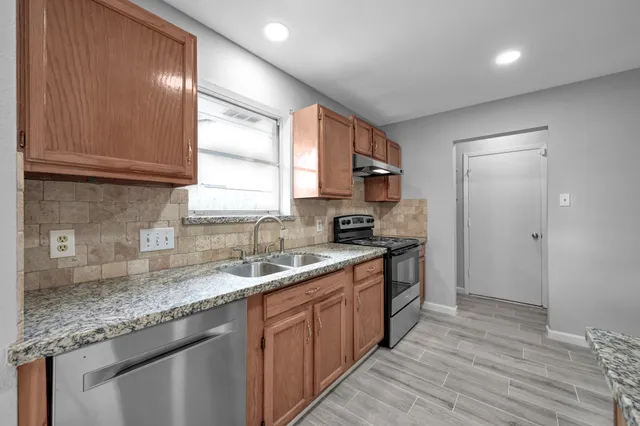 a kitchen with a sink stove and cabinets