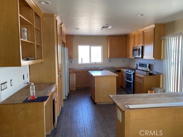 10645 East Ave R 12 Littlerock, CA 93543 - Photo 6 of 23 a kitchen with kitchen island a sink a stove a refrigerator and wooden cabinets