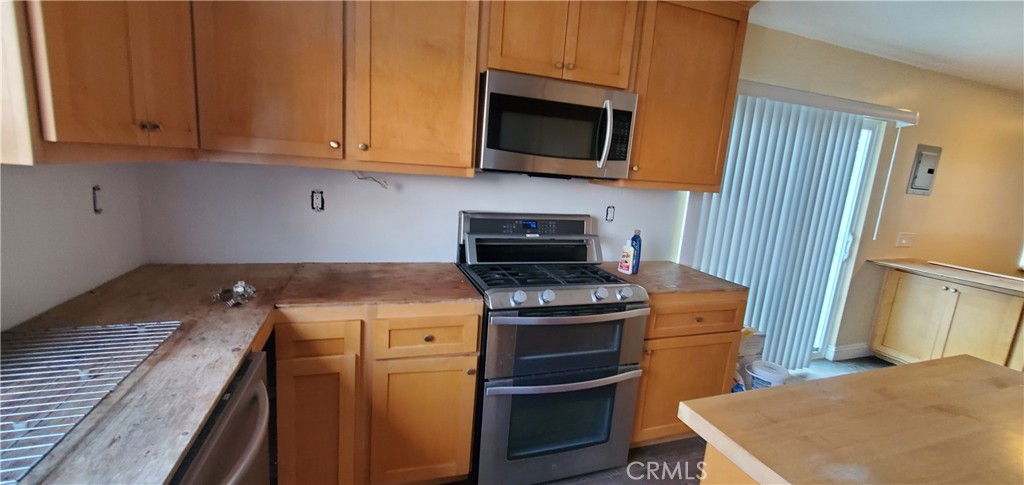 10645 East Ave R 12 Littlerock, CA 93543 - Photo 7 of 23 a kitchen with stainless steel appliances granite countertop a stove a microwave and a refrigerator