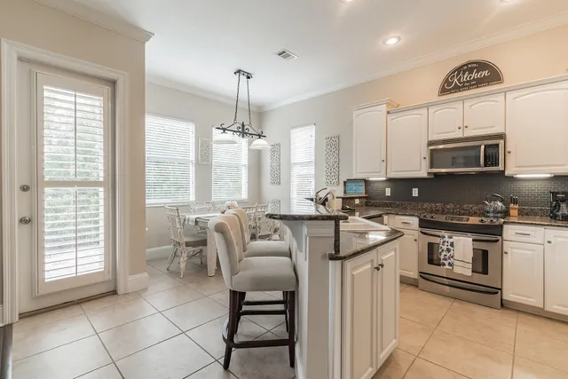 a kitchen with stainless steel appliances granite countertop a stove a sink a microwave and a refrigerator