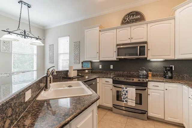 a kitchen with stainless steel appliances granite countertop a stove a sink and a microwave