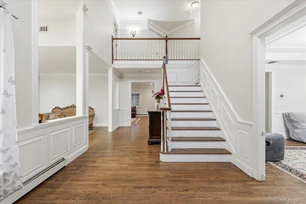 a view of entryway and hall with wooden floor