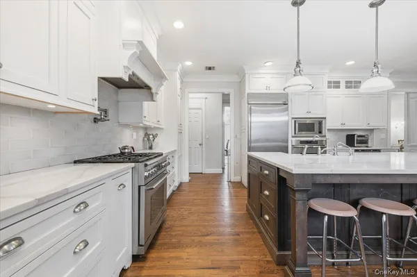 a kitchen with stainless steel appliances granite countertop a sink a stove and a refrigerator