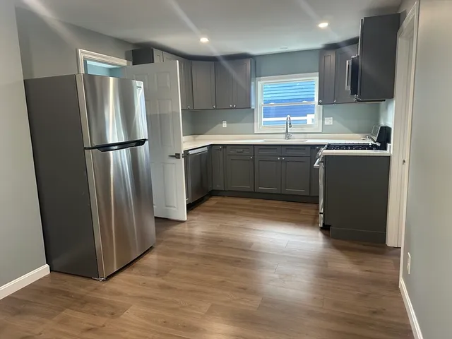 a kitchen with stainless steel appliances granite countertop a refrigerator and a sink