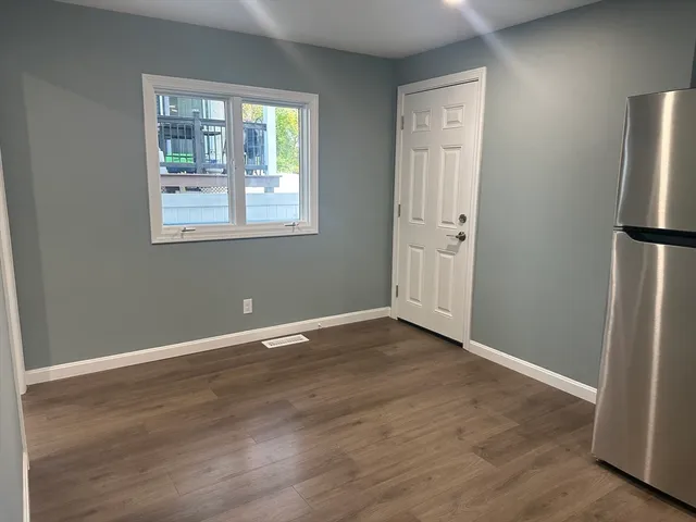 an empty room with wooden floor and a window