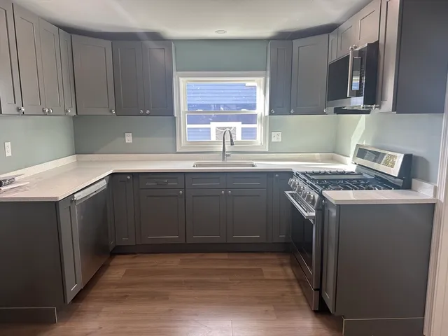 a kitchen with stainless steel appliances granite countertop a sink stove and microwave