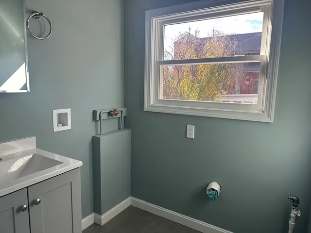a bathroom with a window sink vanity and shower