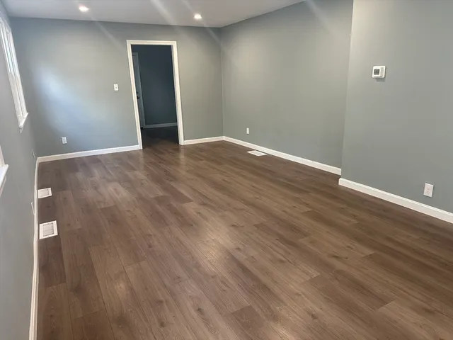 a view of an empty room with wooden floor