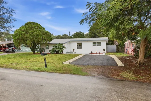 a view of a house with backyard and trees