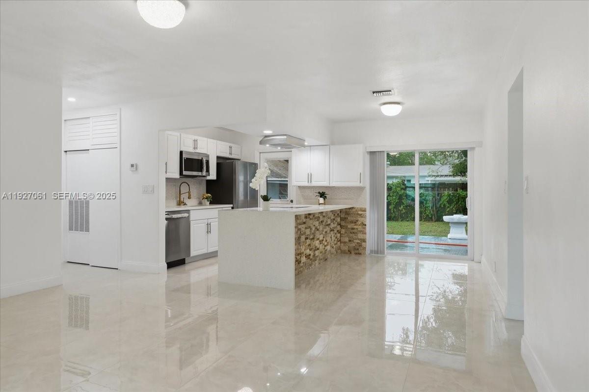 3330 North 72nd Terrace Hollywood, FL 33024 - Photo 5 of 32 a large white kitchen with cabinets and a large window