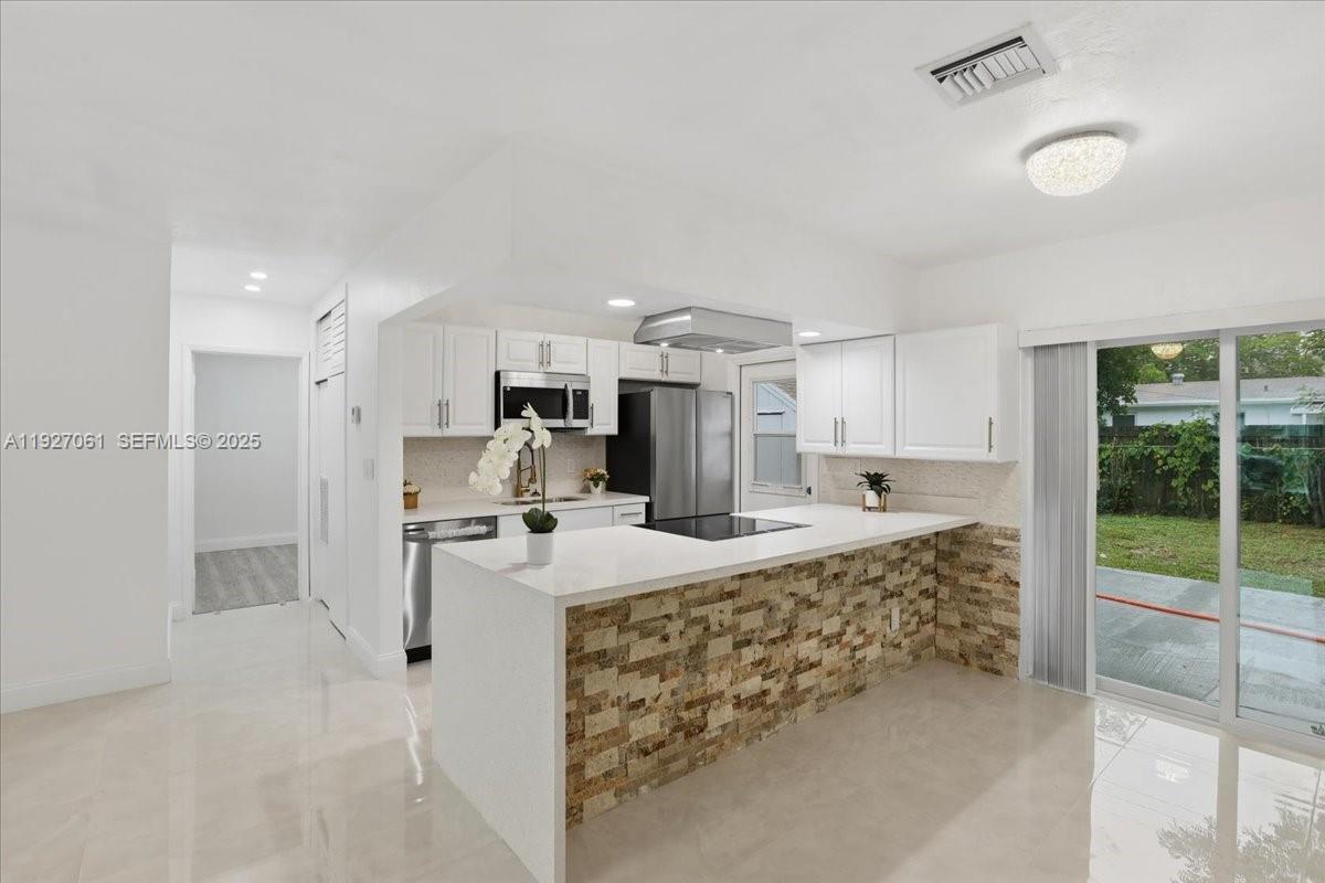 3330 North 72nd Terrace Hollywood, FL 33024 - Photo 6 of 32 a large kitchen with kitchen island a large counter top stainless steel appliances and cabinets