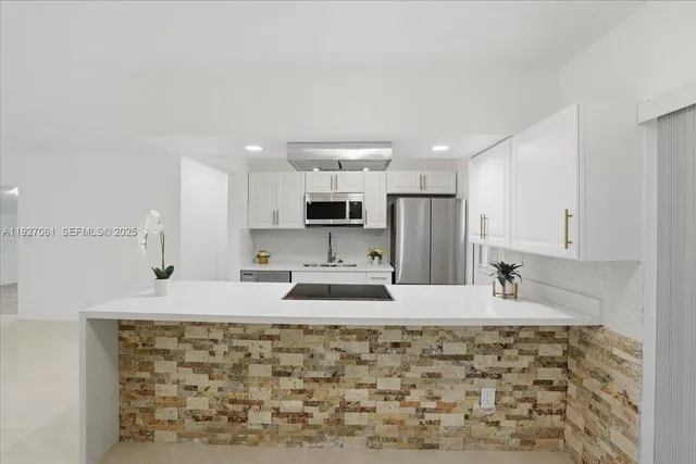 a large kitchen with kitchen island granite countertop a sink and cabinets