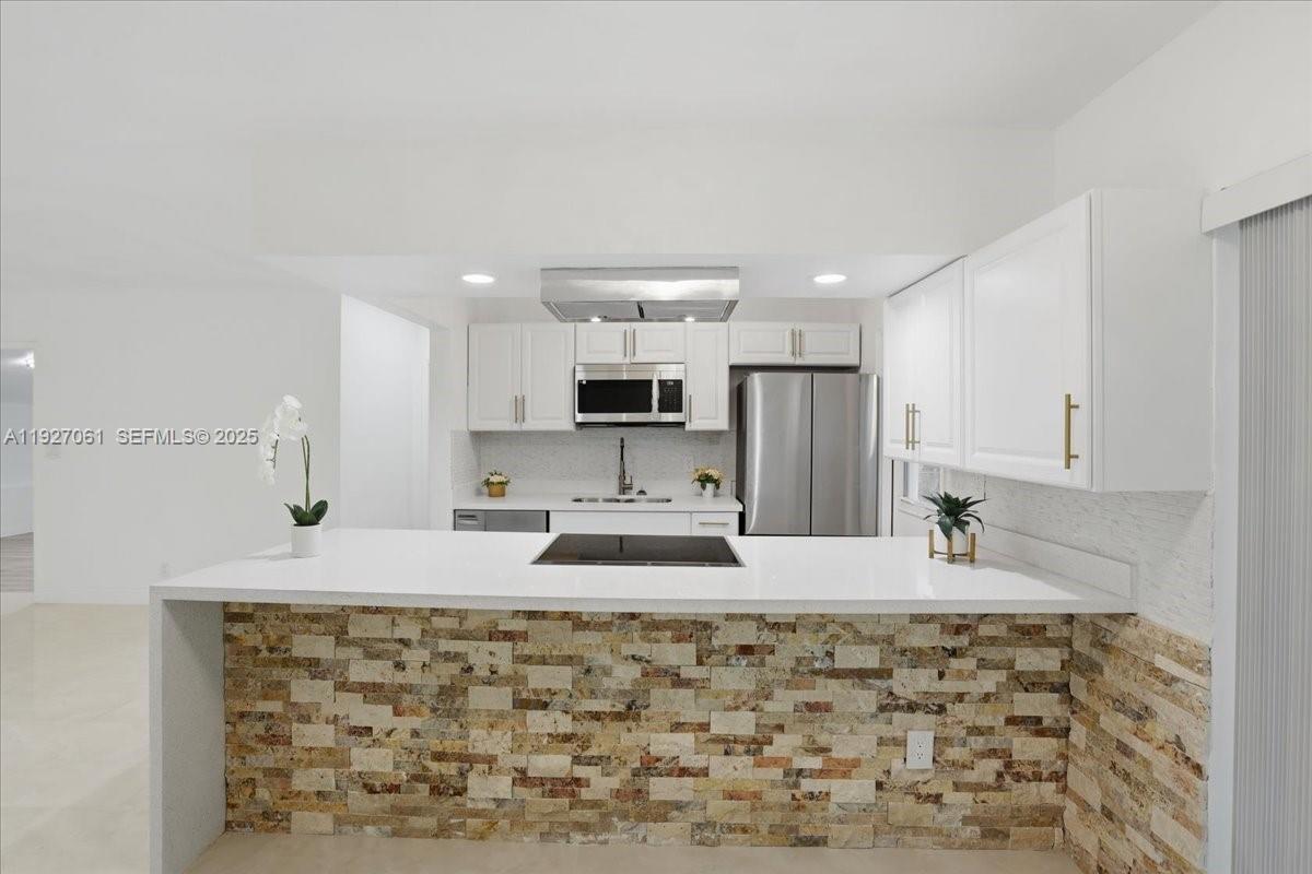 3330 North 72nd Terrace Hollywood, FL 33024 - Photo 7 of 32 a large kitchen with kitchen island granite countertop a sink and cabinets