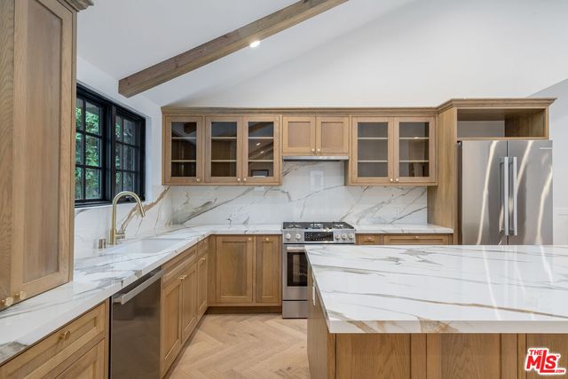 a kitchen with stainless steel appliances granite countertop a sink and a stove