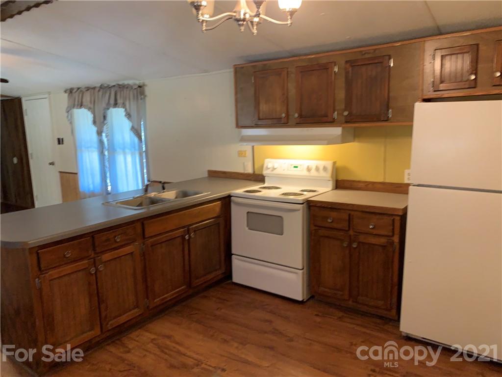 326 Indian Springs Road Clyde, NC 28721 - Photo 12 of 19 a kitchen with a sink a stove a refrigerator and cabinets
