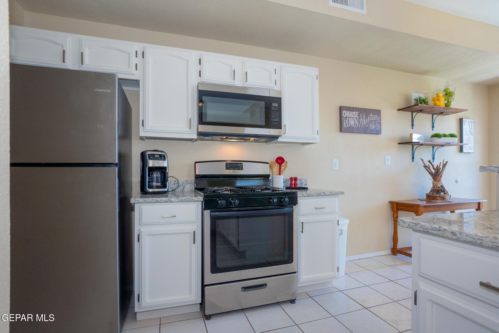 2012 Rogelio Avenue El Paso, TX 79902 - Photo 7 of 12 a kitchen with stainless steel appliances granite countertop a refrigerator stove and microwave