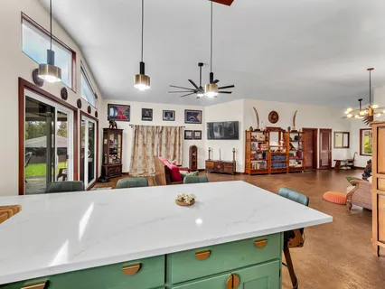 a living room with stainless steel appliances kitchen island a table and chairs in it