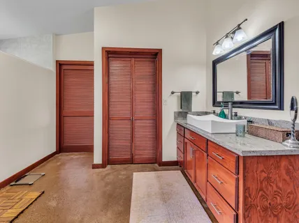 a bathroom with a granite countertop sink and a mirror