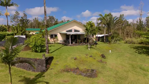 a front view of a house with yard and green space