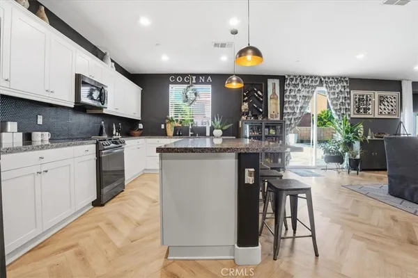 a living room with furniture a flat screen tv and kitchen view