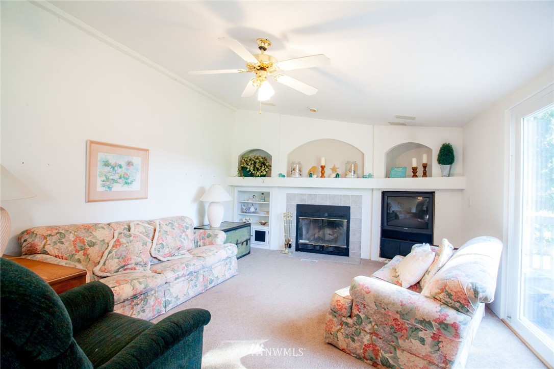 5390 East Harbor Road Freeland, WA 98249 - Photo 6 of 17 a living room with furniture and a fireplace