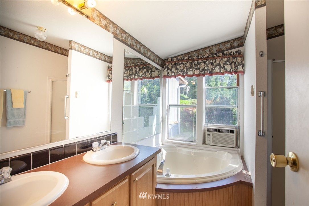 5390 East Harbor Road Freeland, WA 98249 - Photo 10 of 17 a bathroom with a granite countertop sink and a mirror